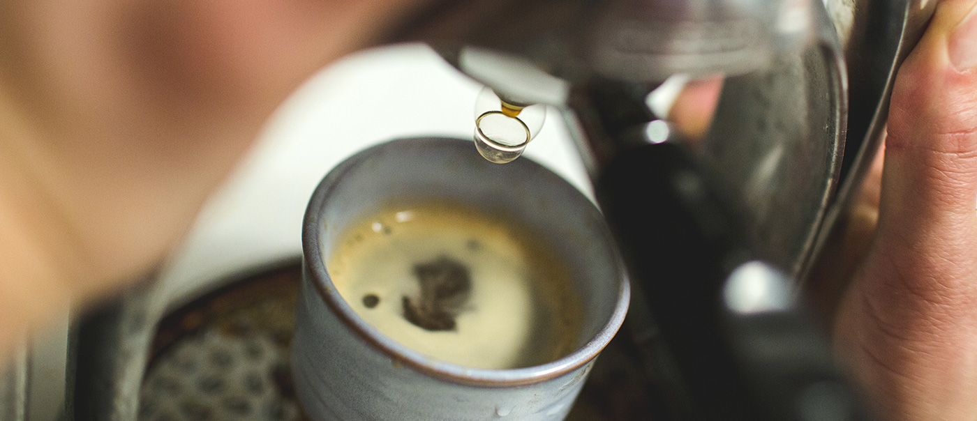 Coffee drips into a mug.