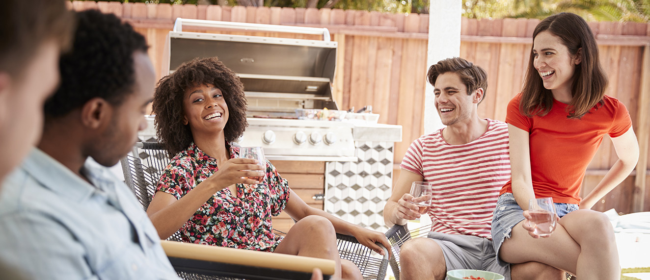 Young people enjoying barbecue in a backyard