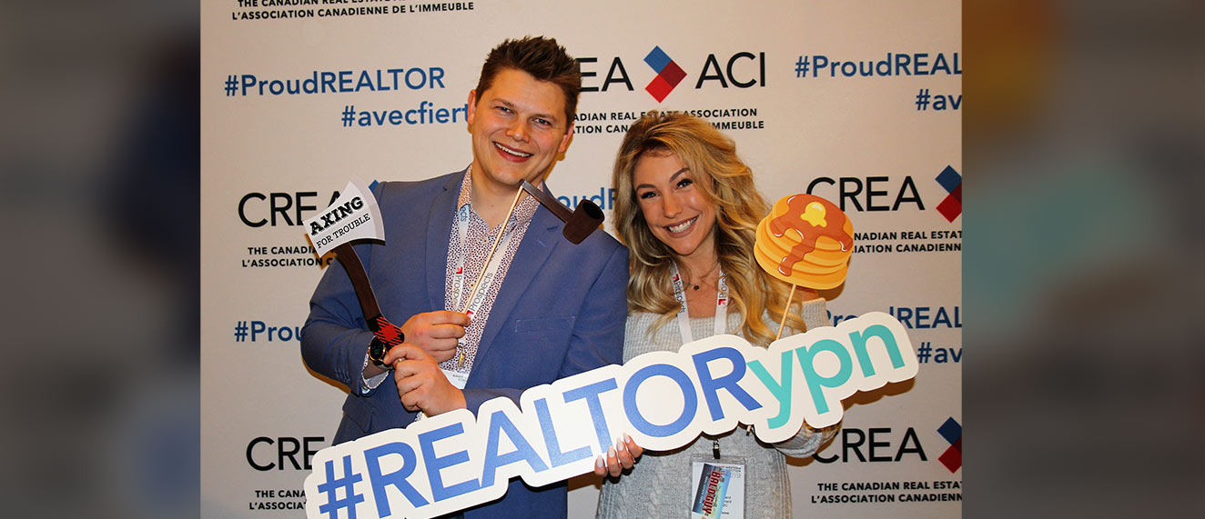 Two young REALTORS(r) holding YPN signs