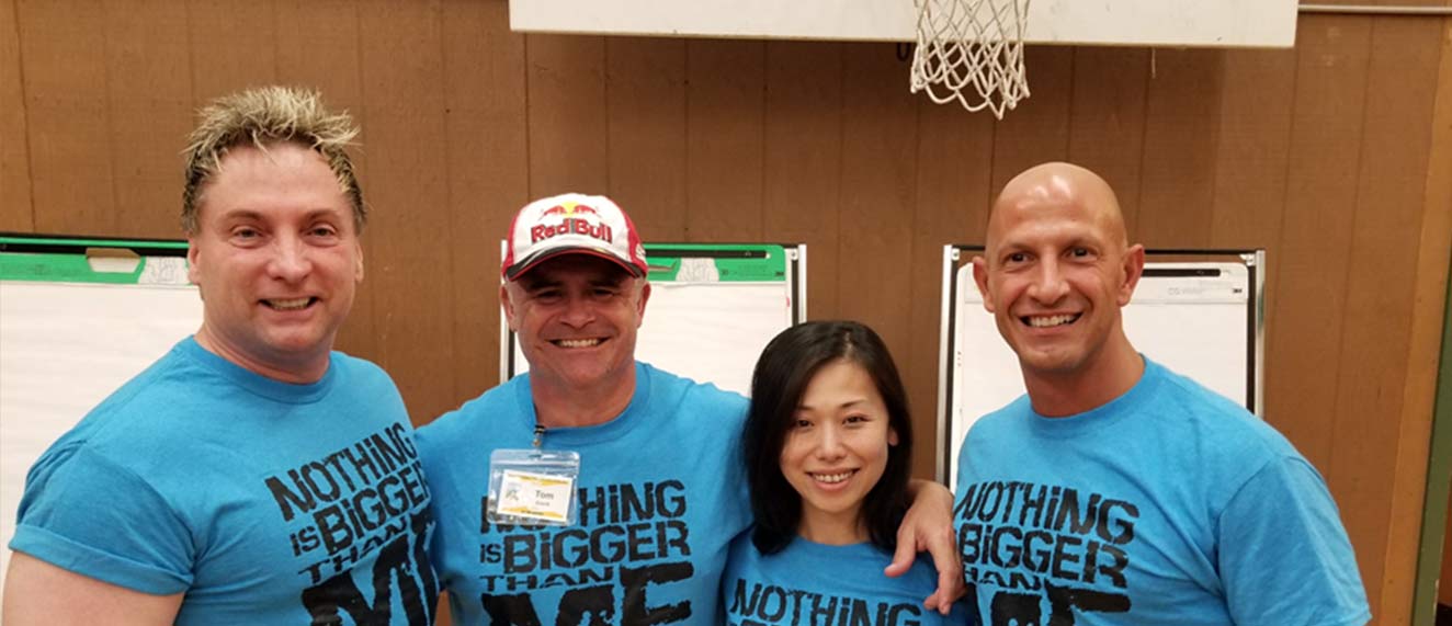 Four REALTORS(r) stand together at a charity event wearing blue shirts