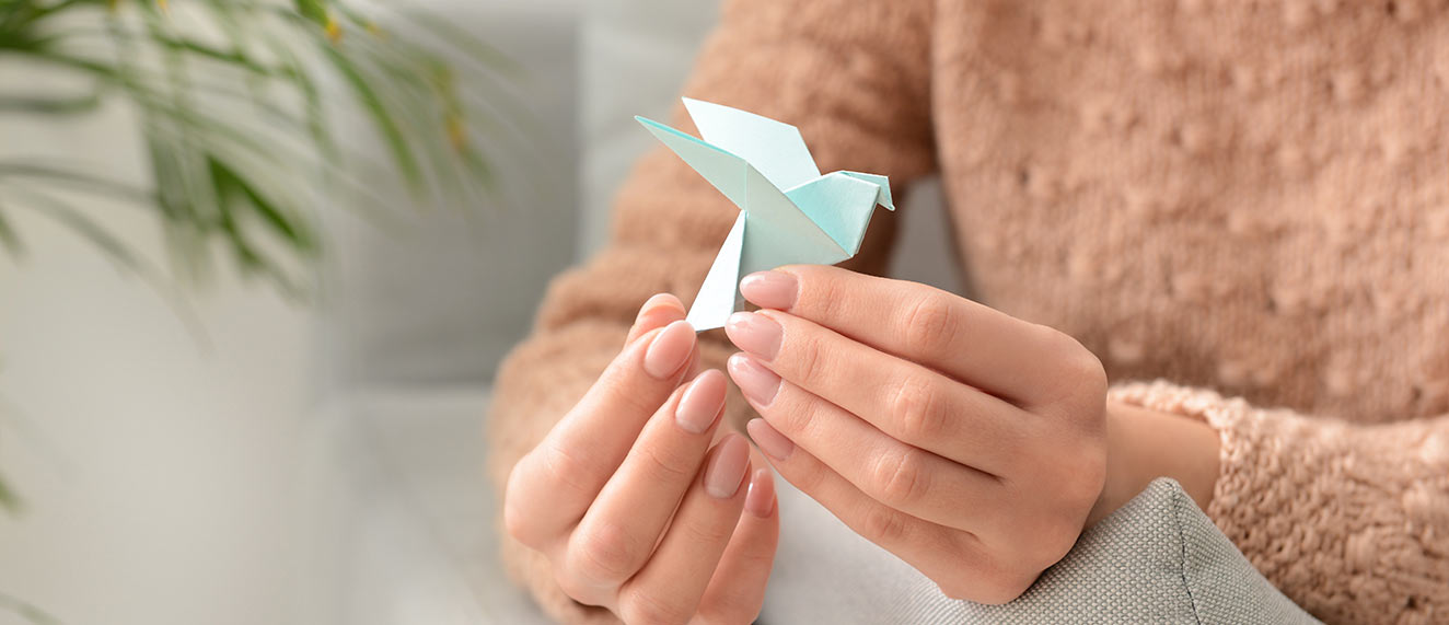 A woman folding an origami swan.