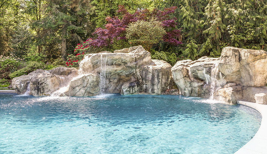 Backyard pool with rock water feature.