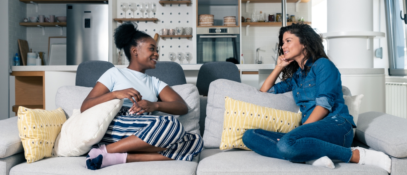 Two young women siting on a couch in a trendy condo.