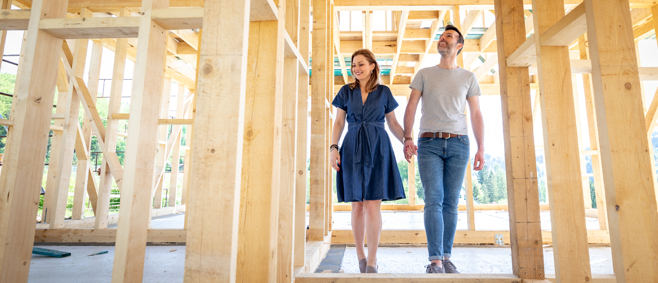 Happy couple walking through new build home.