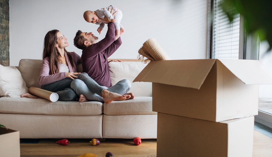 Young family with baby and moving boxes