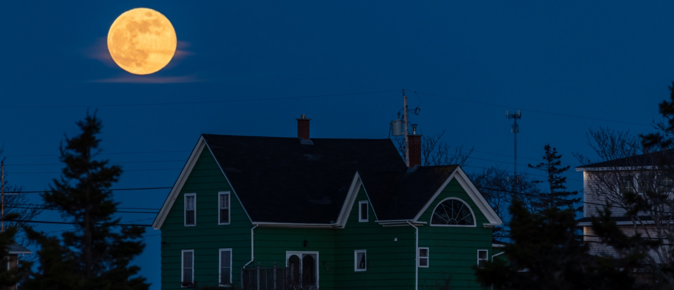 Old house shown in the shadow of moonlight.