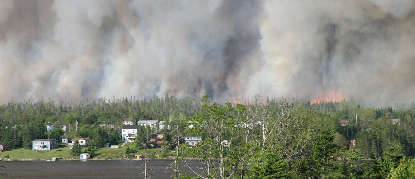 Wildfires burning with community in foreground.
