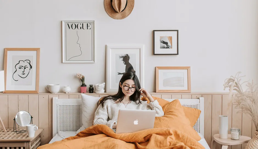 Woman on laptop in bed.