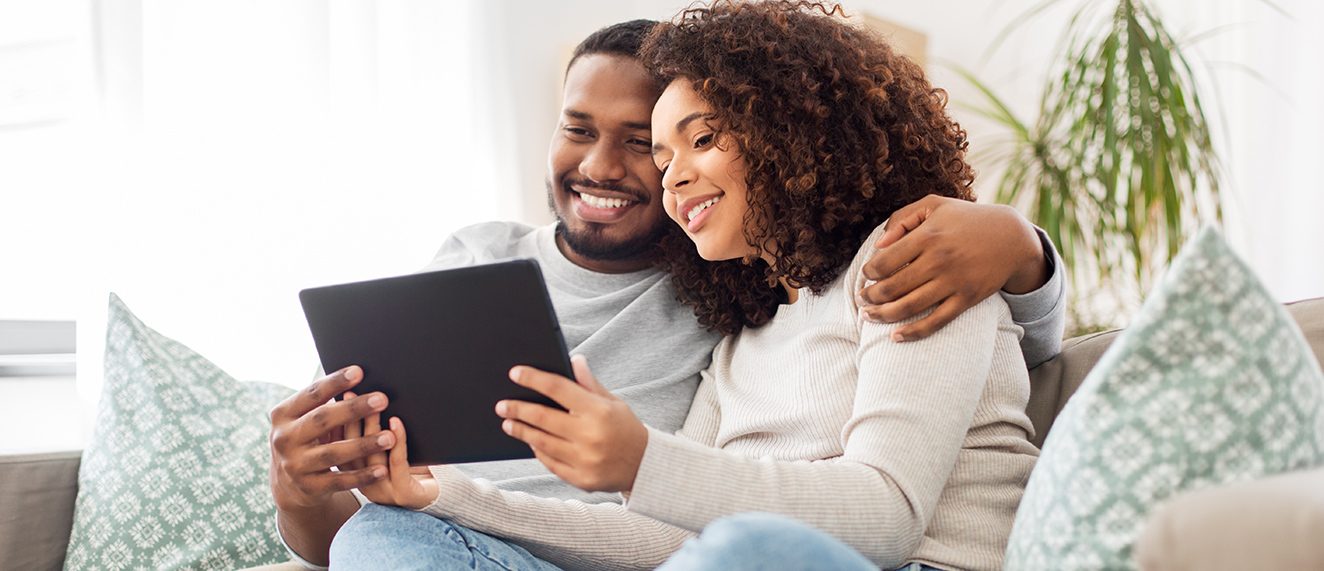 Couple on couch with tablet.
