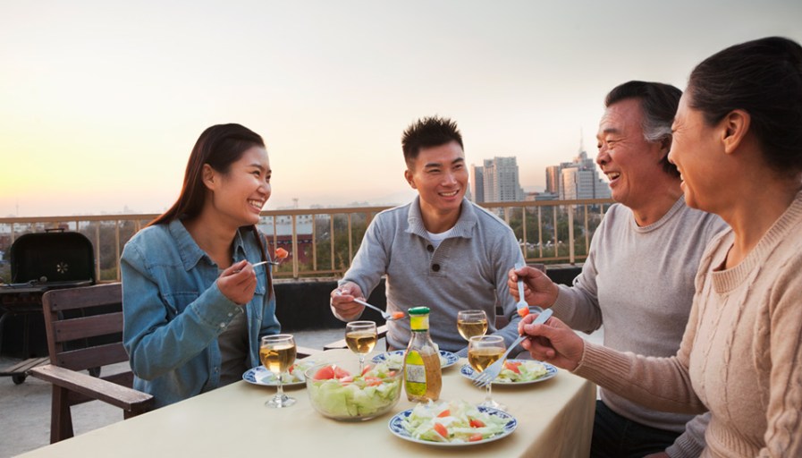 Four people eating dinner on a roof.